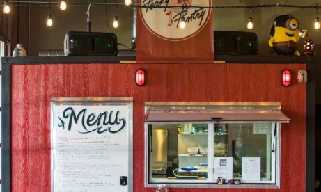 Side view of The Perky Pantry red food cart with large menu sign covering door and serving window with condiment shelf