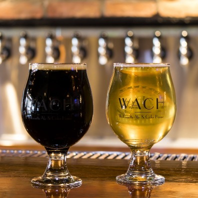 Golden cider and dark stout in tulip shaped glasses on bar at Willamette Ale and Cider House